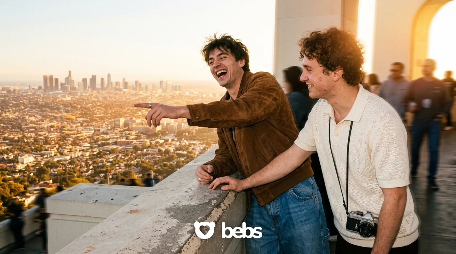 Two young men laughing on a first date at Griffith Observatory at sunset, one of the best free first date ideas in Los Angeles